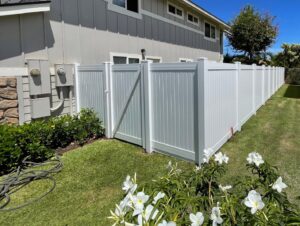 A pristine white vinyl fence with a matching gate, expertly installed by T&G Outdoor Services in Austin, TX.