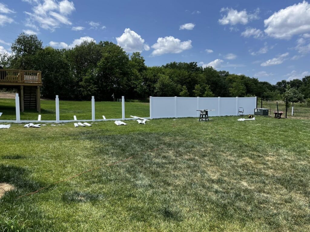 White vinyl fence panels and posts laid out for installation by Custom Vinyl Fabrication in Omaha, NE.