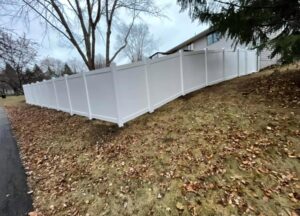 A white vinyl fence installed on sloped terrain by Fencing Company Of Omaha in Omaha, NE.
