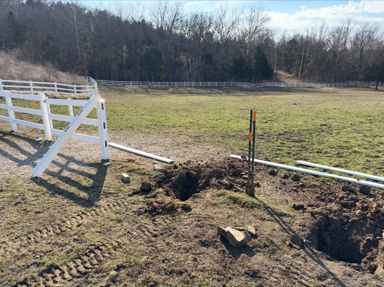 White vinyl fence post installation in progress in an open field by BK FenceWorks in Wentzville, MO.