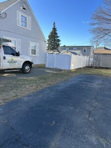 Newly installed white vinyl privacy fence at a residential property, showcasing work by New England landscaping and fence inc in Lynn, MA.