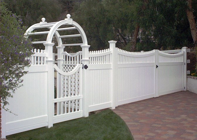 A white vinyl fence featuring an elegant arched gate and trellis installed by AmeriDream Fence & Deck in Joliet, IL.