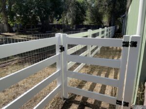 A white vinyl fence with wire mesh infill and a gate, providing a secure enclosure by North CO Fence & Deck in Greeley, CO.
