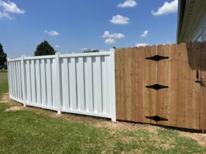 A combination white vinyl fence and wooden gate installed by A-1 Security Fence in Scott, LA.
