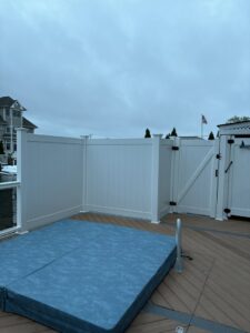 A white vinyl privacy fence installed around a hot tub area on a deck by MAC Fencing LLC in Toms River, NJ