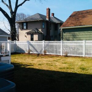 A white vinyl picket fence installed in a residential backyard by OMA Fence,LLC in Weymouth, MA