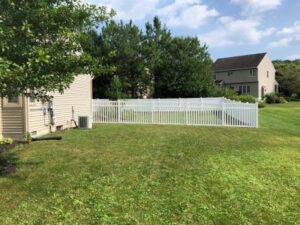 A white vinyl picket fence installed in a spacious backyard by Hitz Fence in Lebanon, PA.