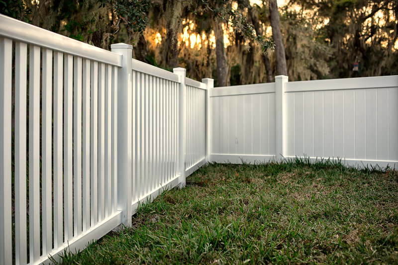 A clean white vinyl picket and privacy fence installed in a residential backyard by Columbia Fence Co. in Columbia Station, OH.