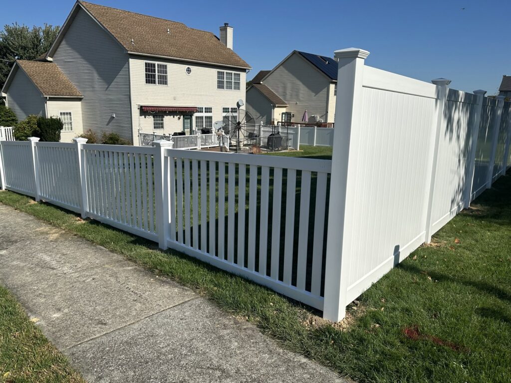 A newly installed white vinyl picket and privacy fence along a sidewalk by Future Solutions Fence Supply in York, PA