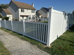 A newly installed white vinyl picket and privacy fence along a sidewalk by Future Solutions Fence Supply in York, PA