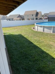 A secure white vinyl fence installed around a swimming pool by ACE and Sons Fence Company in Evansville, IN.