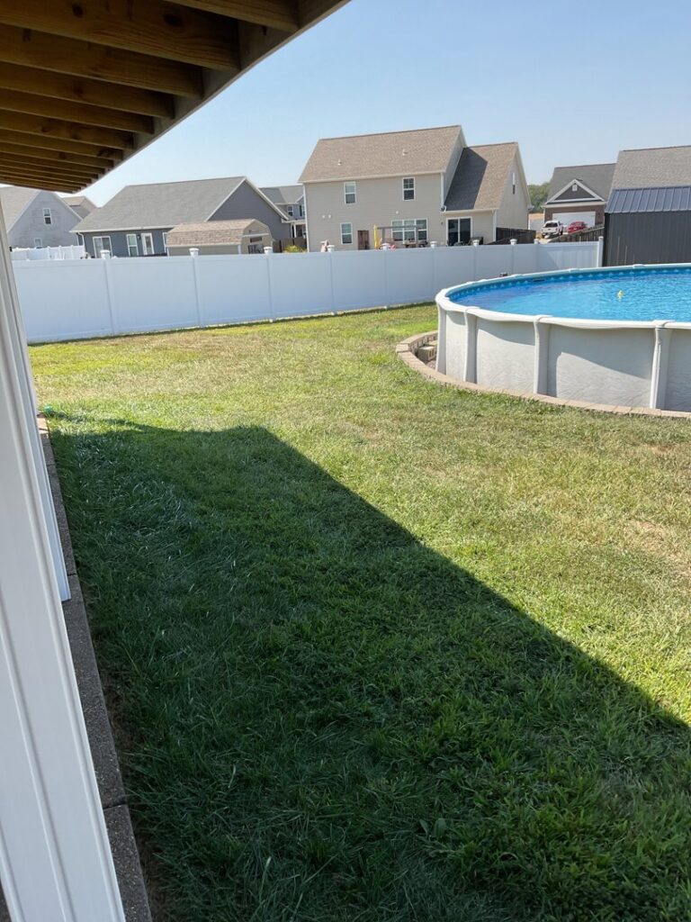 A secure white vinyl fence installed around a swimming pool by ACE and Sons Fence Company in Evansville, IN.