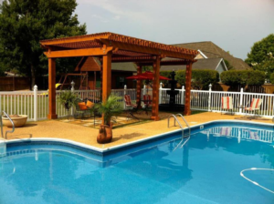 A newly installed white vinyl fence enclosing a pool area with a pergola by Allen Fences & Decks, LLC in Tuscaloosa, AL.