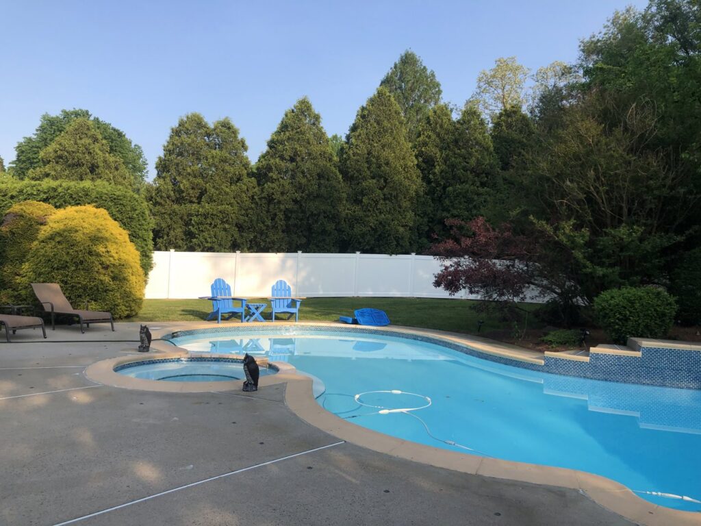 A white vinyl privacy fence installed around a swimming pool area by MAC Fencing LLC in Toms River, NJ
