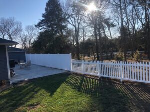 A combination white vinyl privacy and picket fence installed in a residential backyard by Rio Fence Co. in Lincoln, NE.