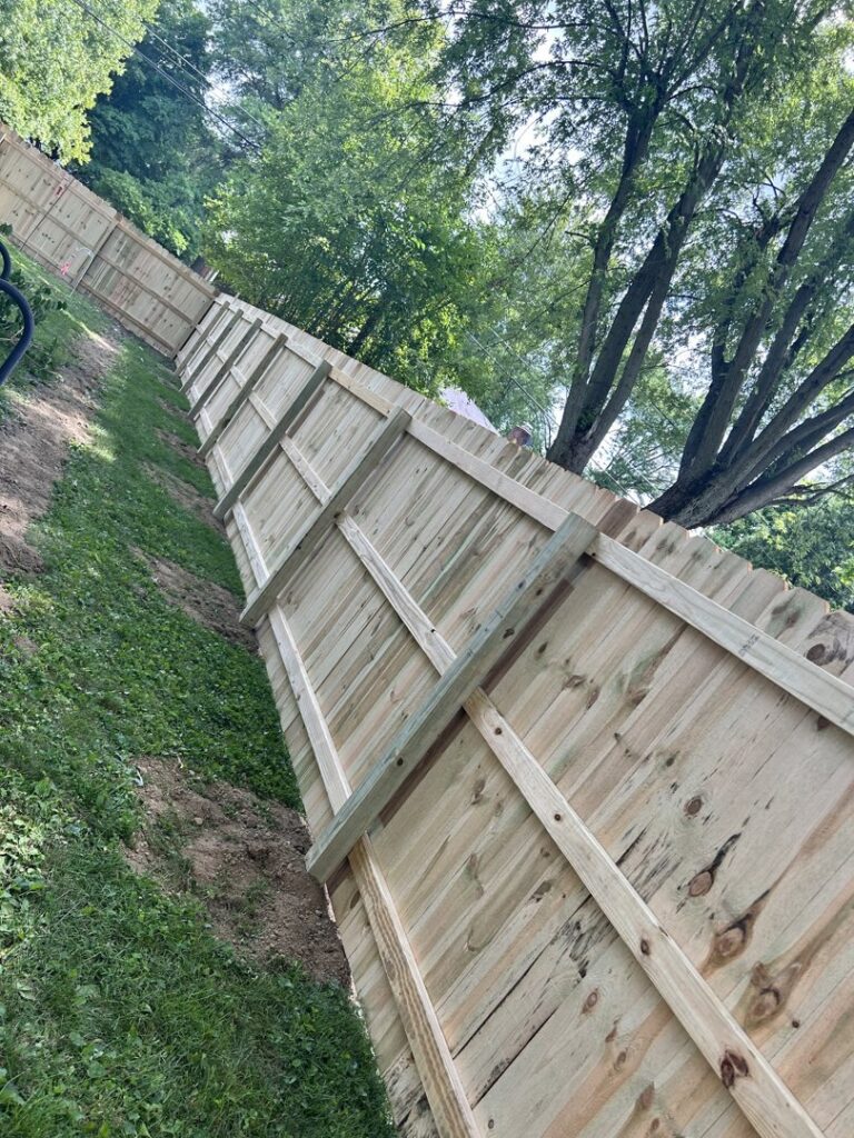 A white vinyl privacy fence installed around a building, showcasing work by Render Fences in Fishers, IN.