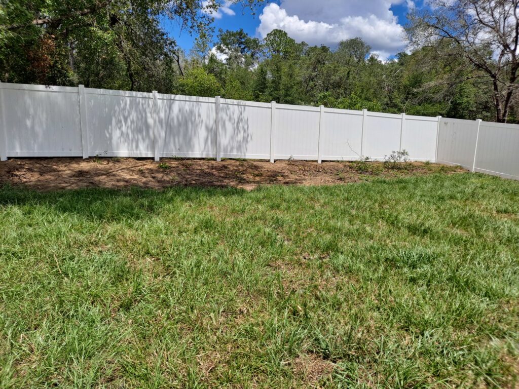 A pristine white vinyl privacy fence installed in a spacious backyard by Aarons fence in Homosassa Springs, FL