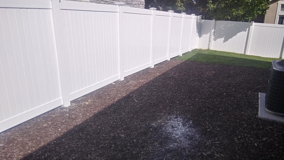 A clean white vinyl privacy fence installed in a residential backyard by Allied Fence Co in Tulsa, OK.