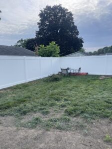 A newly installed white vinyl privacy fence enclosing a residential backyard, completed by Brodeur-Campbell Fence Co. in Springfield, MA.