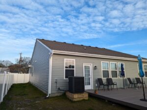 A newly installed white vinyl privacy fence enclosing a backyard behind a house by Fast Fence LLC in Bradenton, FL.