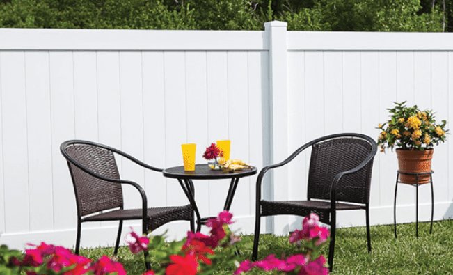 A white vinyl privacy fence providing seclusion for a backyard seating area by Longhorn Fencing Eastern Idaho in Pocatello, ID.
