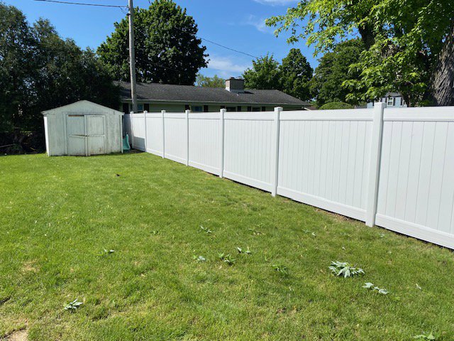 A long white vinyl privacy fence installed in a residential backyard by Safe Yard Fence - Waukesha County in Waukesha, WI.