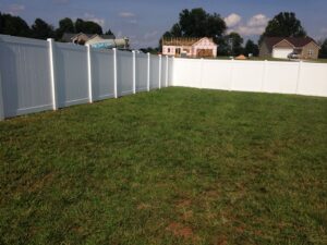 A white vinyl privacy fence installed in a residential backyard by Timber Fencing in Charlotte, NC.