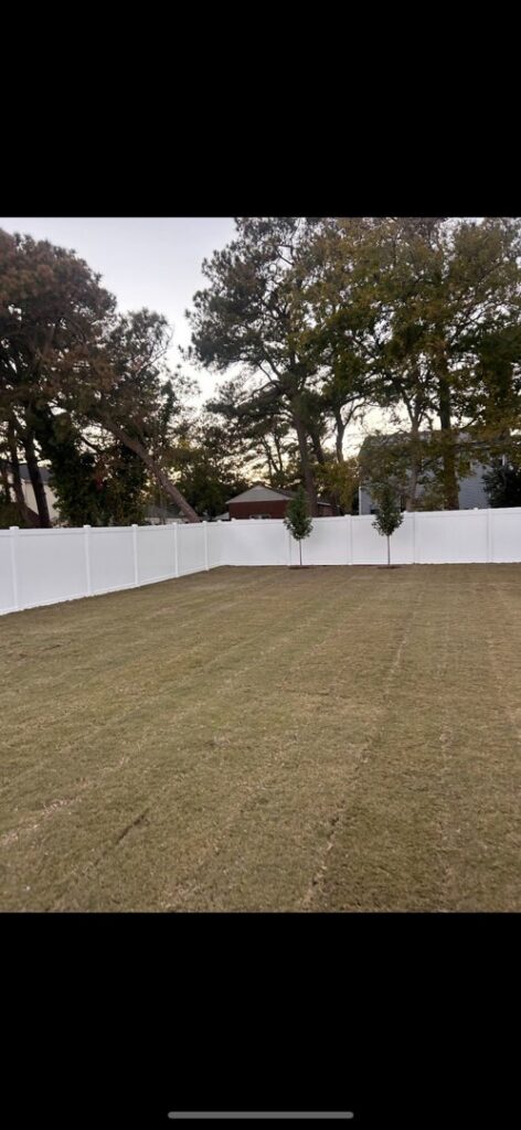 A newly installed white vinyl privacy fence enclosing a backyard by Fast Fence LLC in Bradenton, FL.