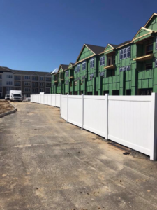 Long white vinyl privacy fence installed at a commercial construction site by Keith's Fence Co LLC in Edison, NJ.