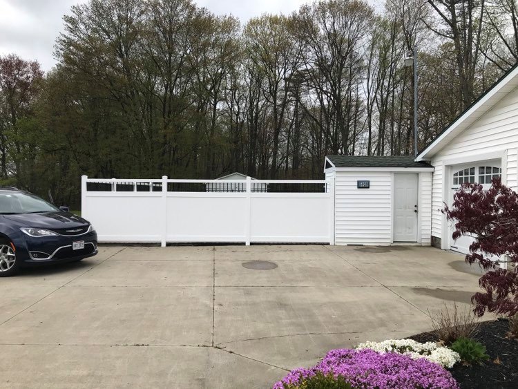A white vinyl privacy fence installed along a driveway by Austintown Fence in Youngstown, OH.
