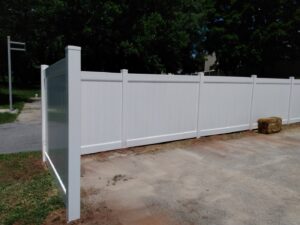 A white vinyl privacy fence installed along a driveway by Snyders Custom Fencing in York, PA.