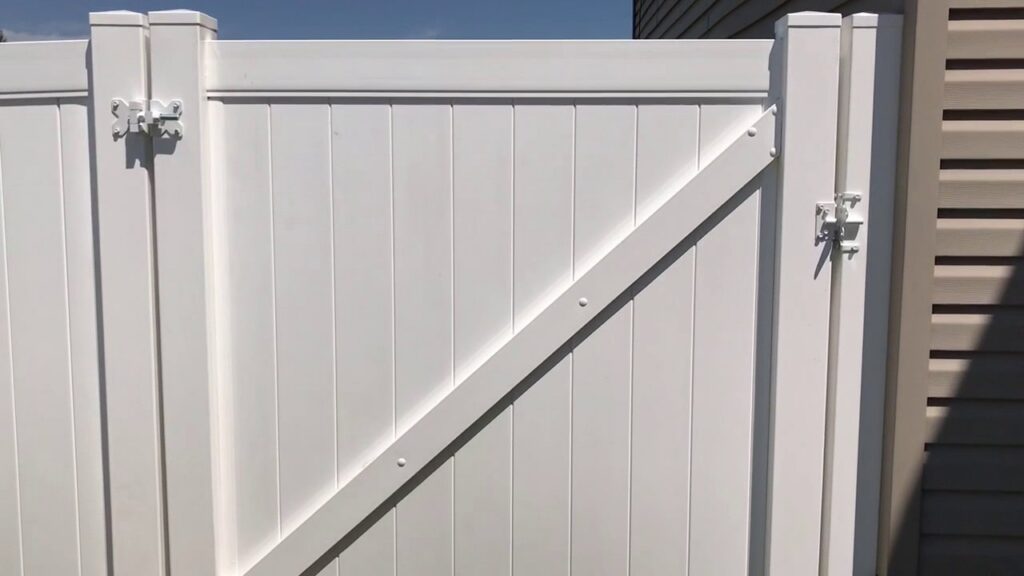 A close-up view of a newly installed white vinyl privacy fence gate by Idaho Falls Fencing in Idaho Falls, ID.