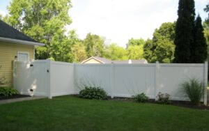 A newly installed white vinyl privacy fence with a matching gate by Metrofence in Grand Rapids, MI.