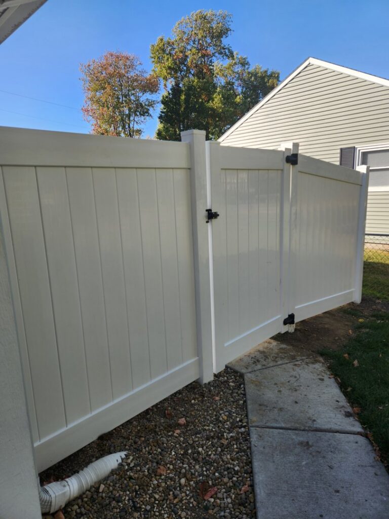 A white vinyl privacy fence with a matching gate installed at a residential property by Cameron Fence Builders in Indianapolis, IN.