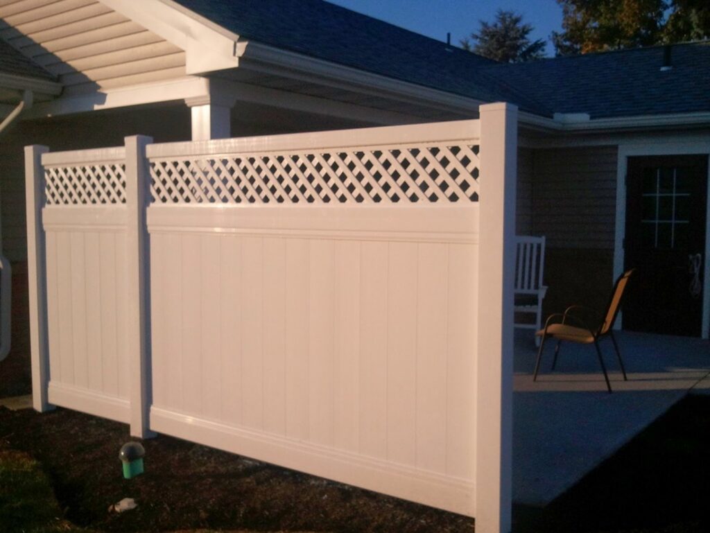 A white vinyl privacy fence with a lattice top installed next to a house by Hitz Fence in Lebanon, PA.