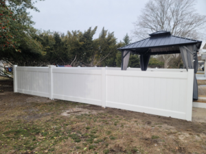 A newly installed white vinyl privacy fence in a residential backyard by AllMasterfence in Toms River, NJ.