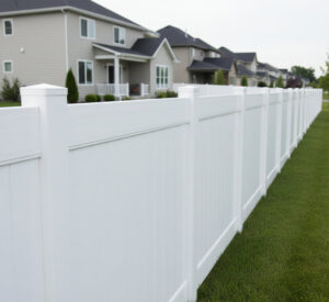 A newly installed white vinyl privacy fence enclosing a residential property by Boost My Home in St. Augustine, FL.