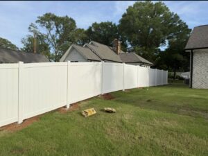 A white vinyl privacy fence installation in a residential backyard by Fencing Company Of Omaha in Omaha, NE.