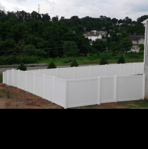 A newly installed white vinyl privacy fence with a gate by Freedom Fence And Outdoor LLC in York, PA.