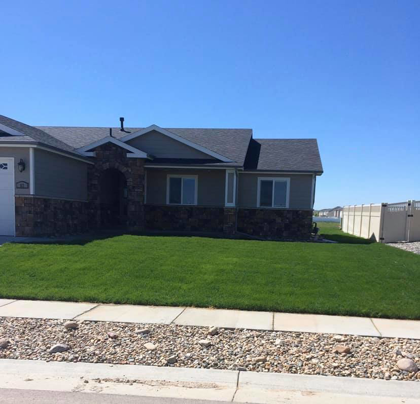 A newly installed white vinyl privacy fence in the backyard of a home by Highmark Landscaping in Gillette, WY.