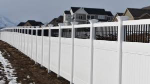 A newly installed white vinyl privacy fence with black accents by Stonehenge Fence & Deck in Orem, UT.