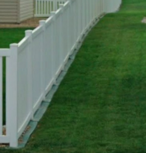 Long white vinyl privacy fence expertly installed for a residential yard by Wildfire Products Inc. in West Fargo, ND