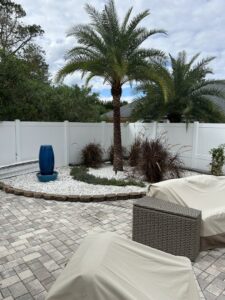 A pristine white vinyl privacy fence enhancing a beautifully landscaped backyard by Fence Nation LLC in Jacksonville, FL.
