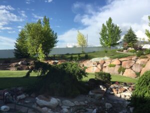 A white vinyl privacy fence installed in a beautifully landscaped yard by Sublime Fencing LLC in North Logan, UT.