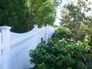 A white vinyl privacy fence complementing backyard landscaping by White Eagle Fence Inc in New Haven, CT.