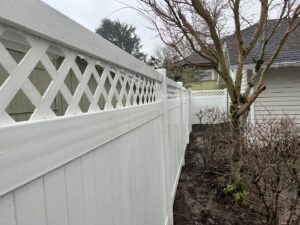 A pristine white vinyl privacy fence with a decorative lattice top, installed by Fence Repair Master in Vancouver, WA.