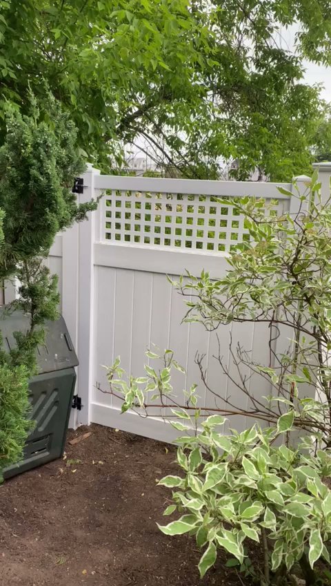 A new white vinyl privacy fence with a decorative lattice top and gate, installed by AVA Fence & Railing LLC in Stamford, CT.