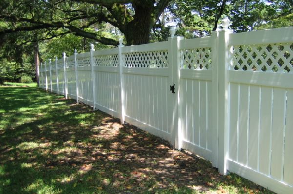 A white vinyl privacy fence with a decorative lattice top and gate, installed by Ozark Fence in Lakewood, CO.