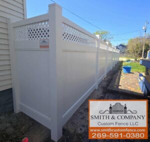 A white vinyl privacy fence with a decorative lattice top, installed by Smith & Company Custom Fence LLC in Niles, MI.