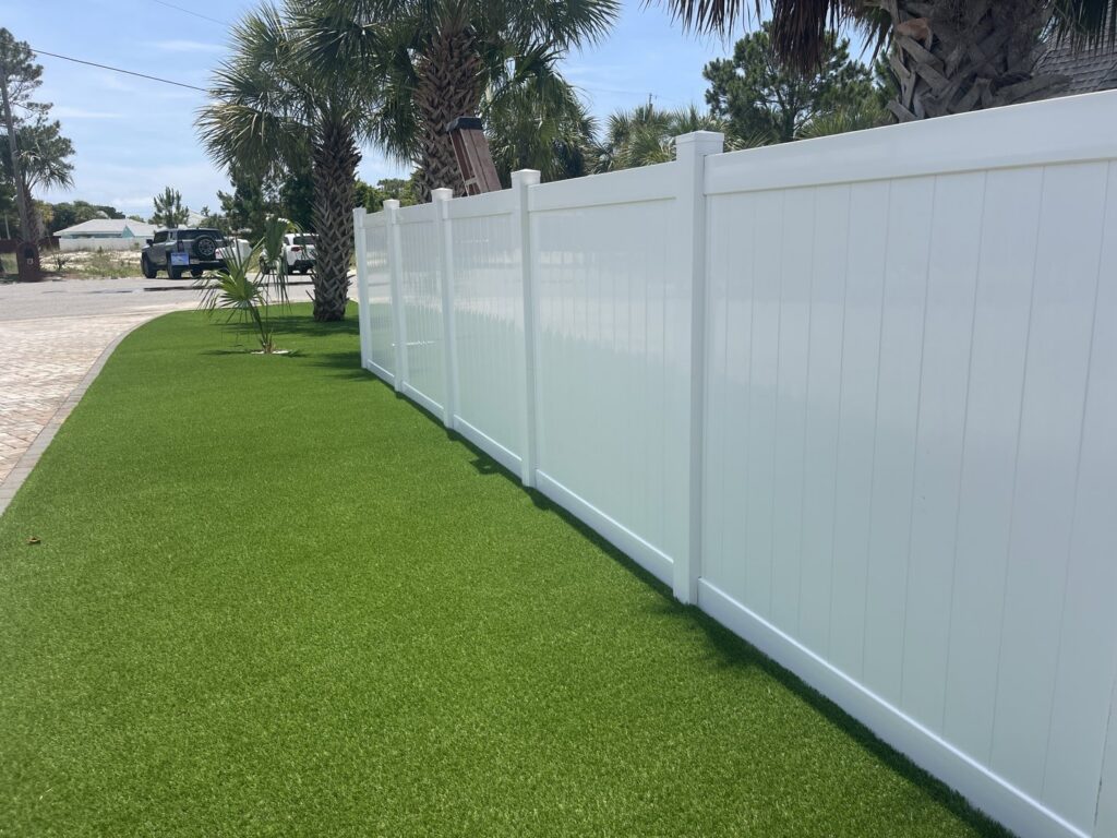 A white vinyl privacy fence installed along a manicured lawn by Superior Fence & Rail of North Shore in Gulfport, MS.